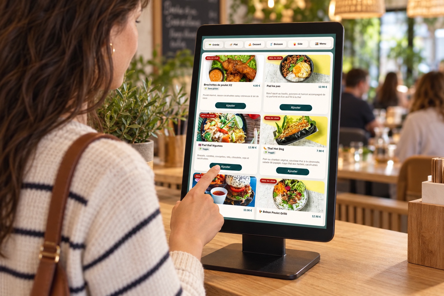 Une cliente choisit un plat sur la borne BEKIOSK au comptoir d’un restaurant, avec l’interface réelle de commande
